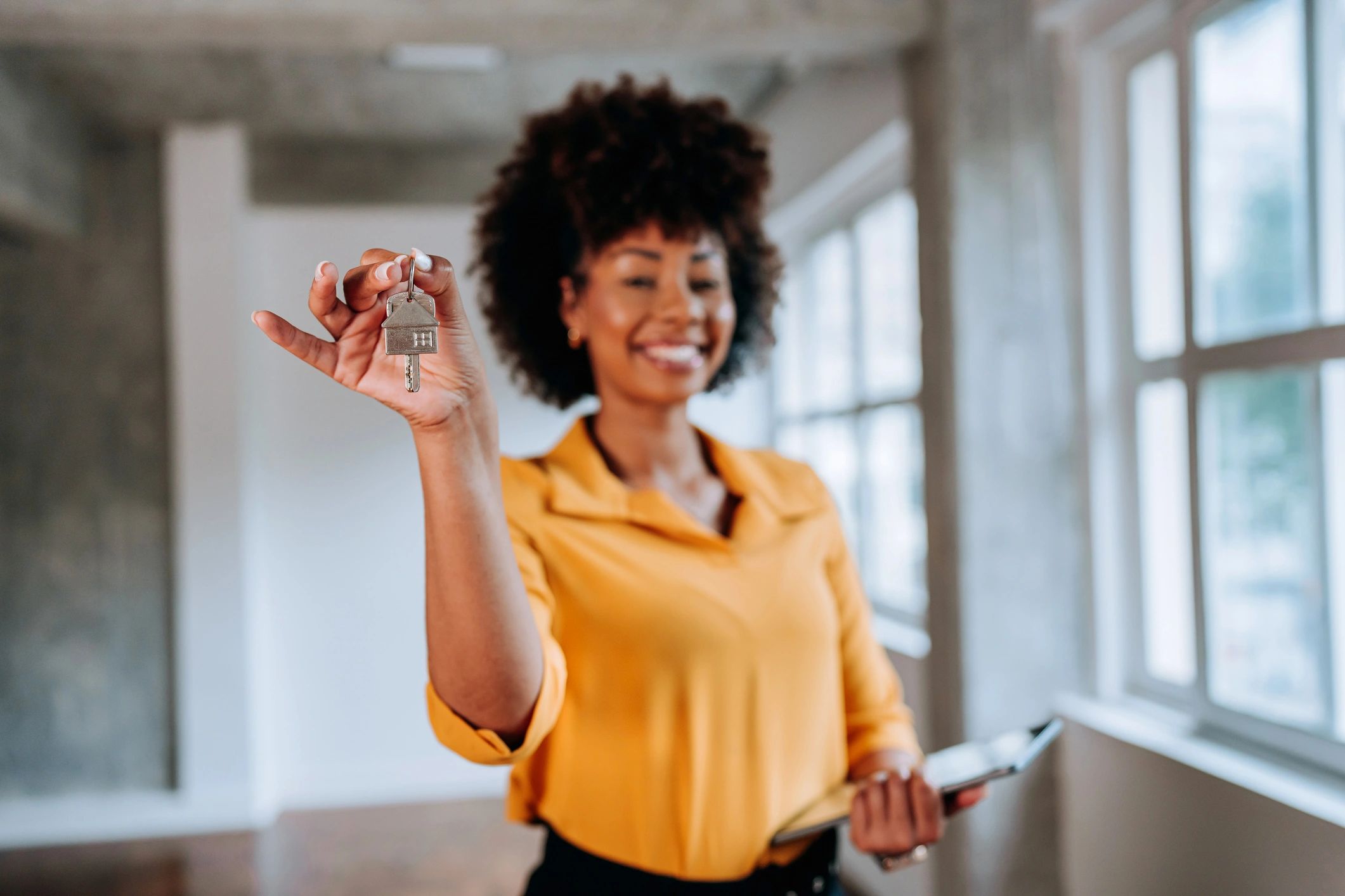 A house key held in hand, symbolizing homeownership